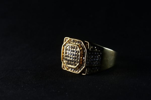Closeup shot of a golden ring with diamonds isolated on a black background